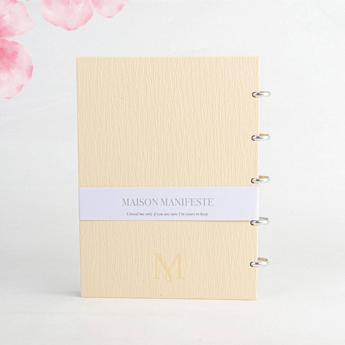 Back cover of the Buttercream A4 (8.27 x 11.69 in) discbound notebook: belly band, embossed 'M' monogram