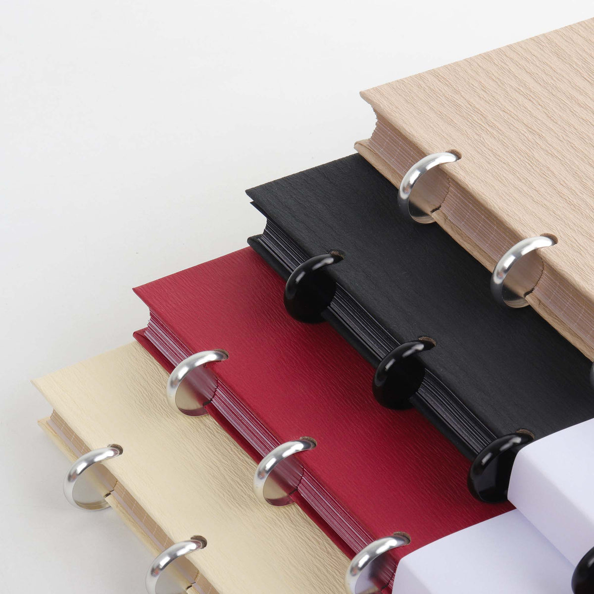 Set of Maison Manifeste discbound notebooks in Buttercream, Black, Chai, and Burgundy, premium writing experience